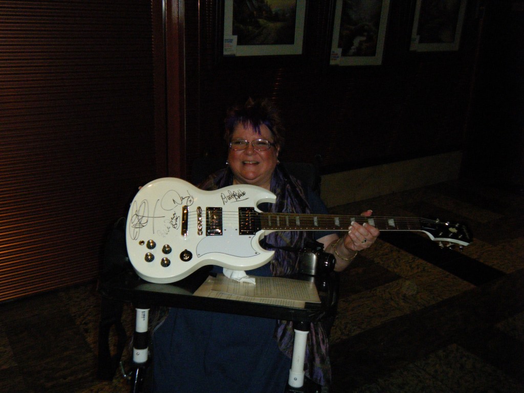 Trish holding guitar autographed by Zoot members